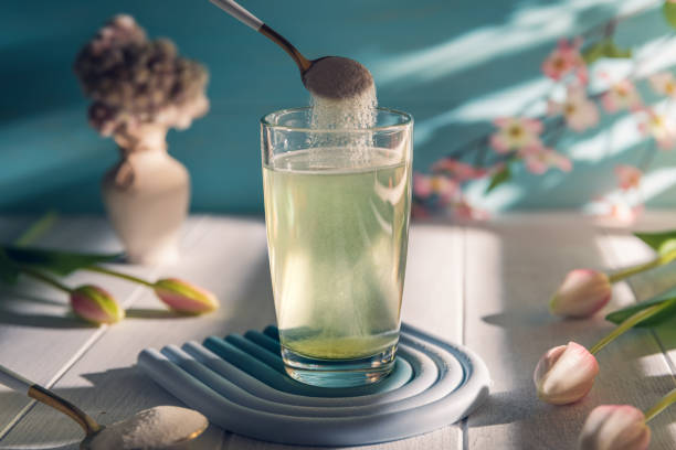 Effervescent Tablet Dissolving in Glass of Water on Table with Flowers and Vase in Background